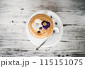 Cup with cappuccino, latte on table, edible flower on top. 115151075