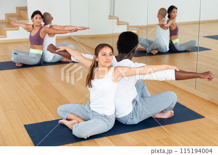 Couples practicing yoga with partner at studio 115194004