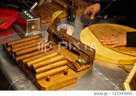 Cigar making with artisans in a traditional workshop, focusing on quality and craftsmanship 115343642