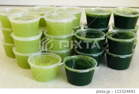 Sprout wheat as called wheatgrass green juice in containers on table for healthy life. Concept of diet, vegan, healthy products. Close-up 115324691