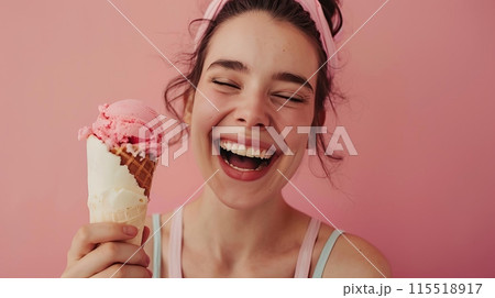 Cheerful woman enjoying a delicious pink ice cream against a pastel pink background, exuding happiness and joy. 115518917