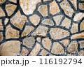 Close up of a stone wall with irregularly shaped stones and dark mortar lines, texture, background. 116192794