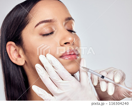 Hands, injection and woman in studio for plastic surgery with beauty transformation and cosmetic procedure. Surgeon needle, client and lip filler for anti aging results and change by grey background 116304240