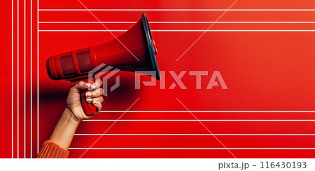 Woman holding a megaphone against a red backdrop with white stripes 116430193