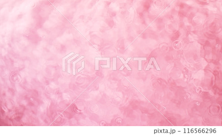 Freeze motion of splashing water surface on light pink background 116566296