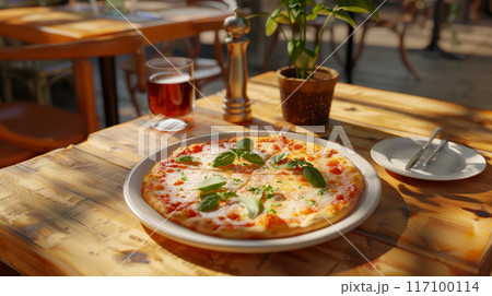 Close-up of fresh baked Italian pizza on old rustic wooden table in restaurant background 117100114