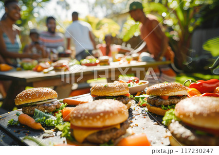 Group of friends enjoying outdoor barbecue with burgers and drinks, summer celebration 117230247