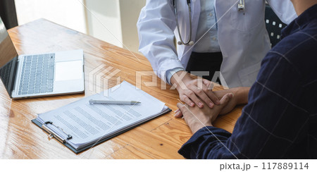 Close-up view of a female doctor giving advice and encouragement to a stressed young patient with health and medical problems in the clinic 117889114