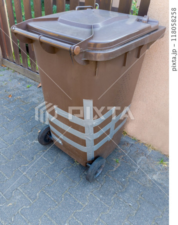 Damaged Brown Waste Bin with Amateur Repair 118058258