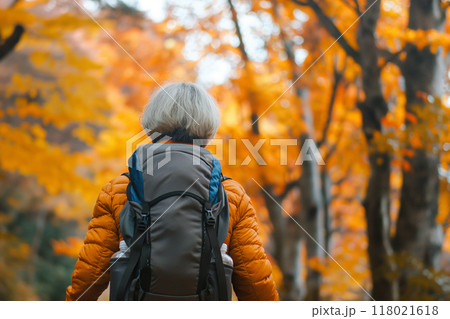 紅葉の山道を歩くシニア女性 118021618