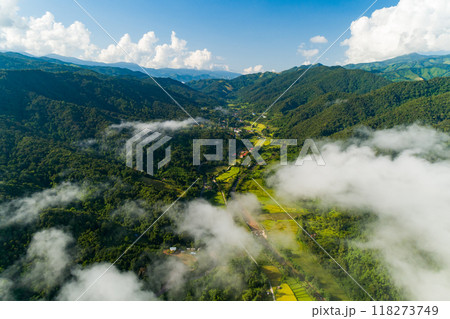 Aerial view drone shot of flowing fog waves on mountain tropical rainforest,Bird eye view image over the clouds Amazing nature background with clouds and mountain peaks 118273749