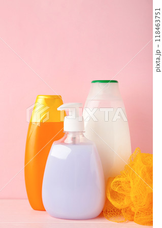 Colored shower gel bottles and sponge on pink background 118463751