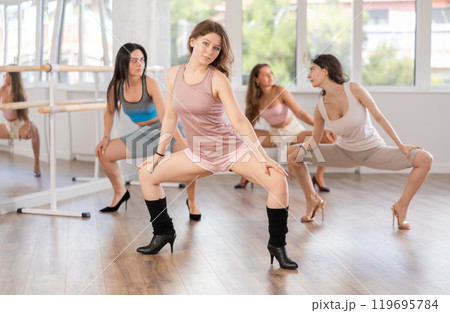 Girls in heels learn to move to beat of music and combine rhythm and smooth movements 119695784