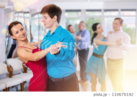 Portrait of adult pairs of different ages enjoying tango in modern dance hall together 110670192