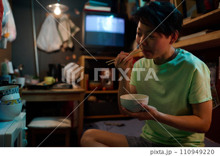 Hungry woman eating food with chopsticks 110949220