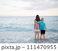 A happy boy and girl in shorts enjoying the beach scenery with water and sky 111470955