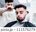 Man in barber shop getting haircut for his hair, beard, and eyebrows 111576279