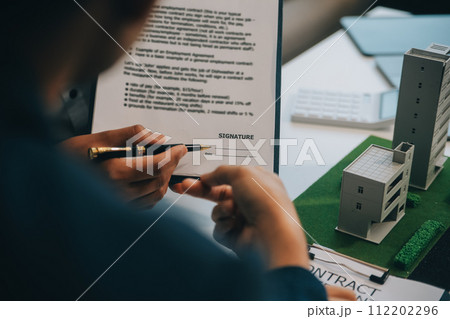 Real estate agent talked about the terms of the home purchase agreement and asked the customer to sign the documents to make the contract legally, Home sales and home insurance concept. 112202296