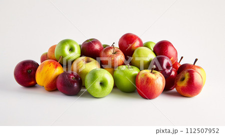 A bountiful selection of fresh, vibrant fruits are scattered artfully on the pristine white background 112507952