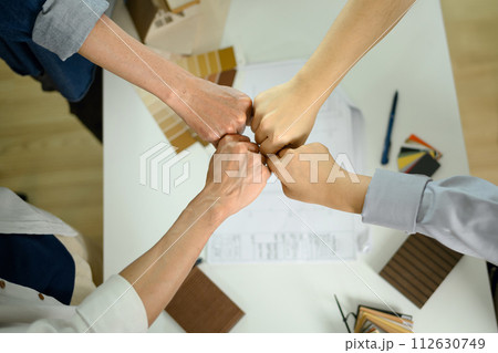 Overhead view architects joining their hands together in unity and teamwork 112630749