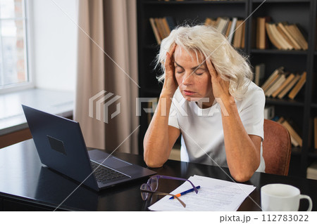 Headache pain. Middle aged woman touching temples experiencing stress. Mature old lady tired of work feeling headache sick rubbing temples forehead. Long laptop usage computer vision office syndrome 112783022