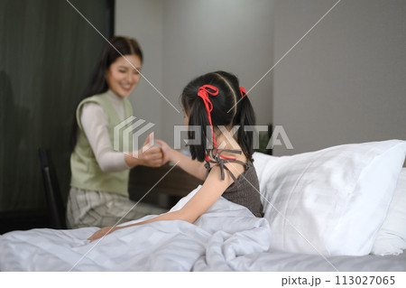 Happy loving mother and daughter having fun and playing together in the bedroom 113027065