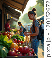 Woman shopping at outdoor farmers market in summer morning light 120152672