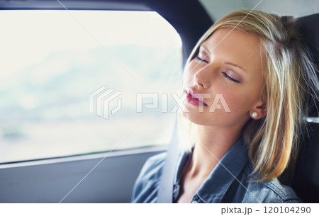 Driving in luxury. Shot of an attractive young woman asleep in the backseat of a car while on a roadtrip. 120104290