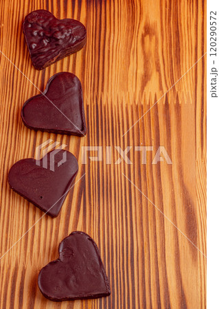 Four chocolate hearts vertically on a wooden table, Valentine's day concept 120290572