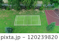 Tennis Grass Court Aerial Top View. Ascending aerial shot of basketball and tennis courts in an urban American park, in morning light, with long shadows, captured from above by a drone. 120239820