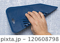 Applying a blue squeegee tool on a textured wall for effective cleaning and maintenance 120608798