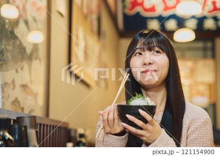 海鮮丼を美味しそうに食べる女性　撮影協力・ピアbandai 121154900