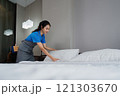 cleaning service woman worker clean bedroom at hotel. housekeeper cleaner feel happy and make bed look neat. housework and housekeeping cleaning service 121303670