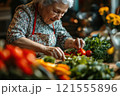 Elderly woman preparing fresh vegetables in a cozy kitchen culinary art indoor close-up passion for cooking 121555896