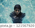 Arabian woman in burkini swims in the pool 121567920