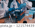 Blood test in the laboratory. Laboratory assistant working with the dispenser. Vacuum tubes with blood. 121574439