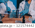 Blood test in the laboratory. Laboratory assistant working with the dispenser. Vacuum tubes with blood. 121574442