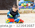 Little cute toddler boy three years old plays in the sandbox on a spring day. Outdoor development activities for kids. Toy cars and shovel 121641687