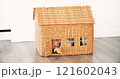 A happy little girl smiles and waves from a generic rustic doll house. Real estate related new home, small house or mortgage concepts 121602043