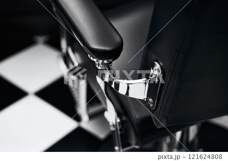 Modern barber chair detail in stylish black and white barbershop interior 121624808