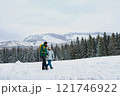 Dad and girl in the middle of snowy nature. Hiking in winter mountains. Winter family walk. 121746922