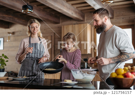 Family making pancakes, preparing sweet breakfast in the morning. 121756157