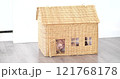 A smiling little girl inside a generic wicker doll house. Real estate concept 121768178