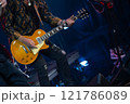 Guitarist performs energetically on stage during live rock concert event 121786089