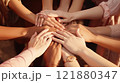 Group of multicultural women stacking hands together in a supportive gesture. Emphasizes unity 121880347