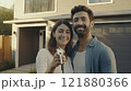 Happy young couple holding keys and smiling in front of their new house. Ideal for real estate 121880366