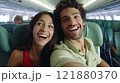 A cheerful couple smiles while taking a selfie inside an airplane. Perfect for capturing the joy of 121880370