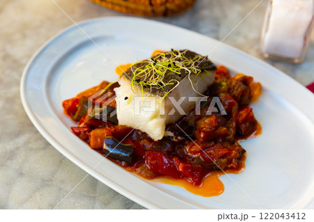 Cod confit with vegetable ratatouille on plate 122043412