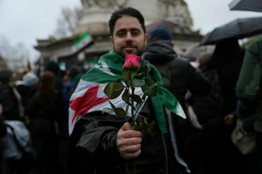 Ein Mann zeigt eine Rose während einer Kundgebung auf dem Platz der Republik in Paris