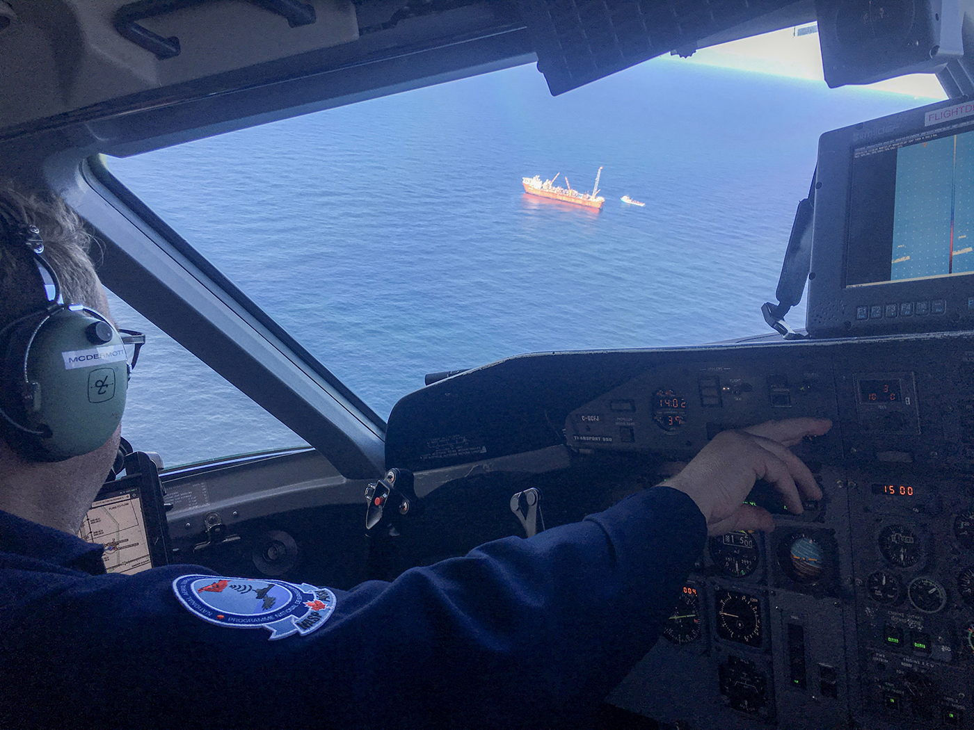 A vessel is seen through the pilot’s window of a NASP surveillance plane as it patrols the water for pollution.